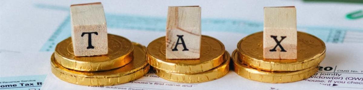 wooden blocks with letters spelling tax on gold coins