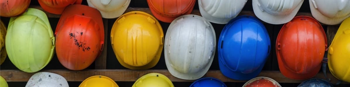 selection of multi-coloured hard hats representing the construction sector