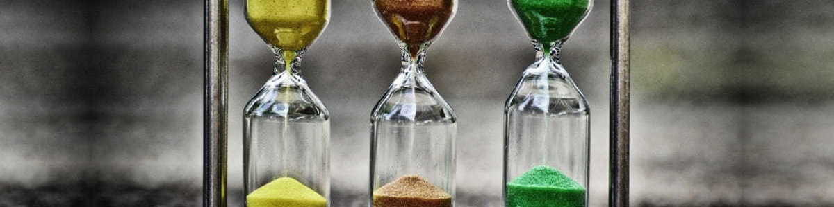 Three hourglasses with coloured sand running through them.
